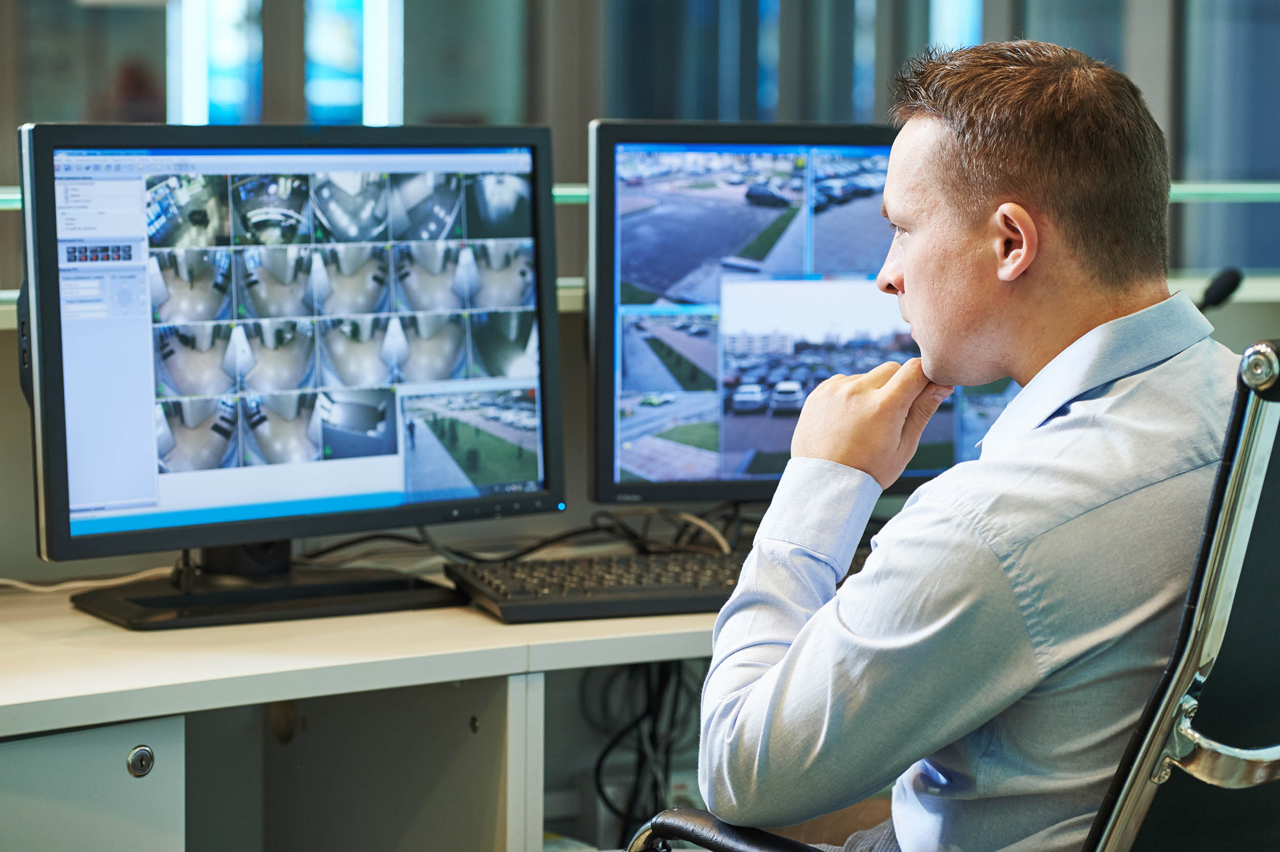 man looking at security screens